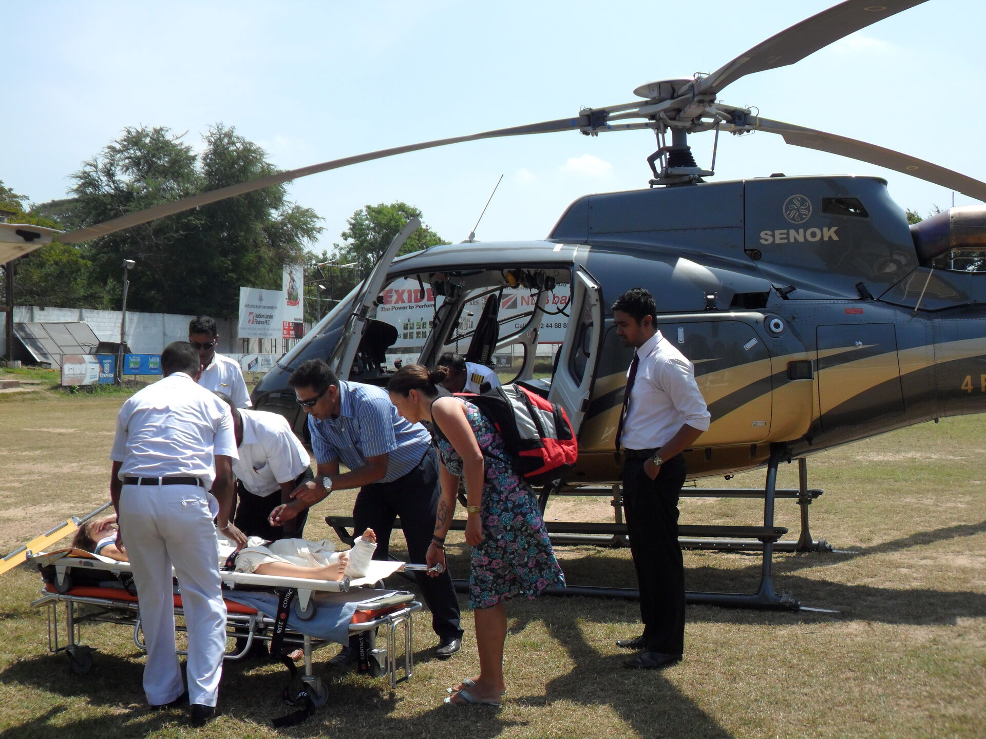 Medical crew transferring a patient beside a Senok helicopter